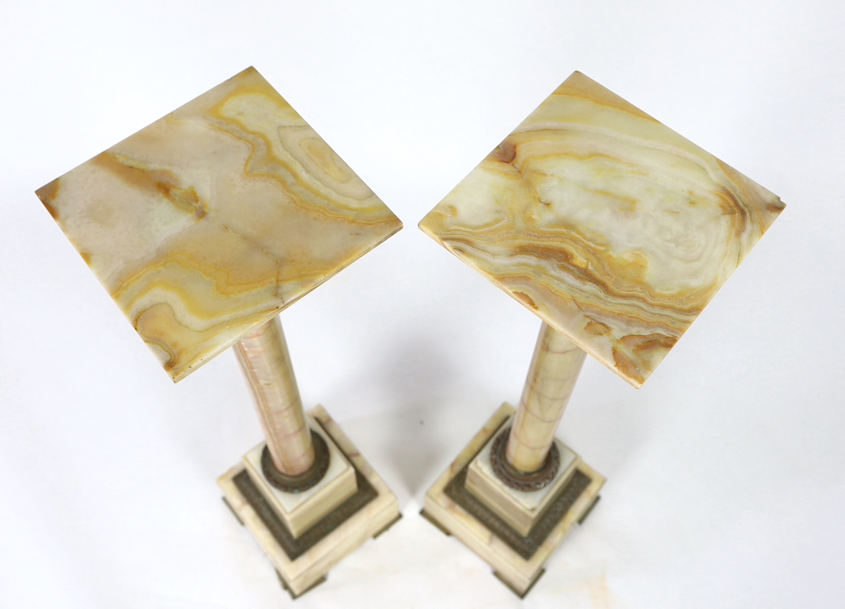 A pair of early 20th century French ormolu mounted onyx pedestals, width 25cm, height 99cm